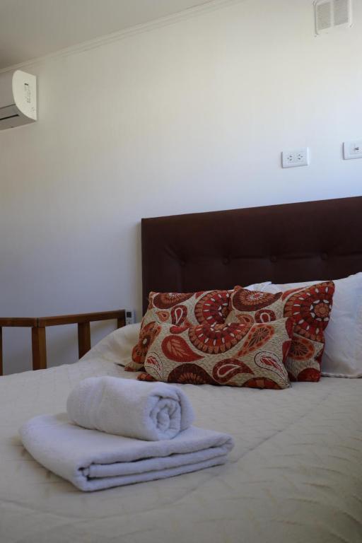 łóżko z 2 ręcznikami i poduszką w obiekcie Belgrano 360 w mieście Tandil