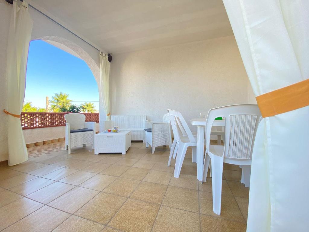 Zimmer mit einem Tisch und Stühlen sowie einem Balkon in der Unterkunft Villa Vistasalentina BIS Appartamento Delux in Torre Colimena