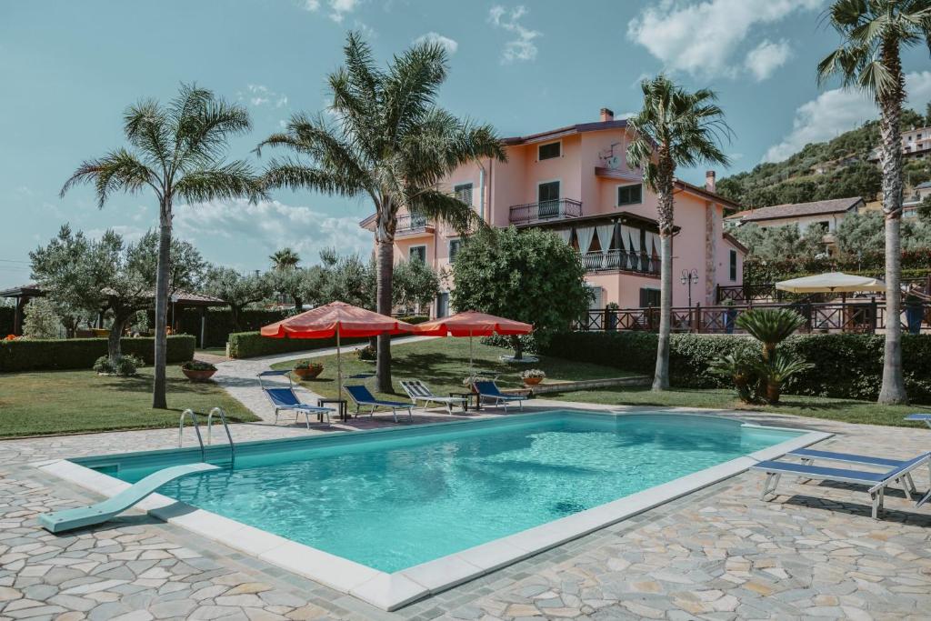 a pool with chairs and umbrellas in front of a building at Villa Santimone in Eboli