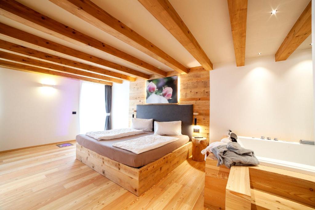 a bedroom with a bed in a room with wooden floors at B&B fiordimelo in Cavalese