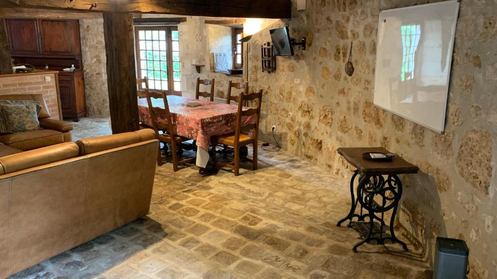 a living room with a table and a dining room at Gite du moulin in Pranzac