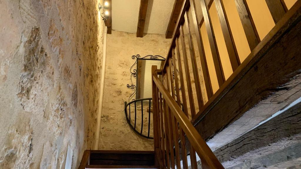 a staircase in an old building with a metal railing at Gite du moulin in Pranzac