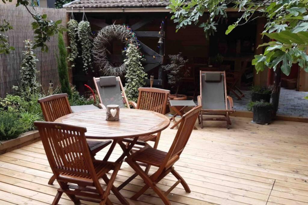 a wooden table and chairs on a wooden deck at La Maison du Rempart in Eguisheim