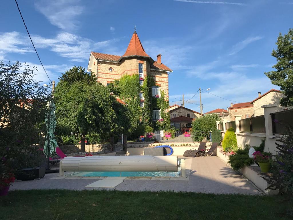 un grande edificio con piscina di fronte di Belle maison de famille a Usson-en-Forez