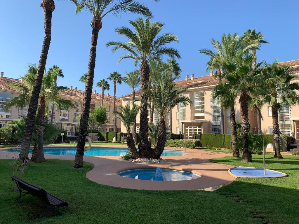 un edificio con palmeras y piscina en Luxury Apartments Golden Beach Javea, en Jávea