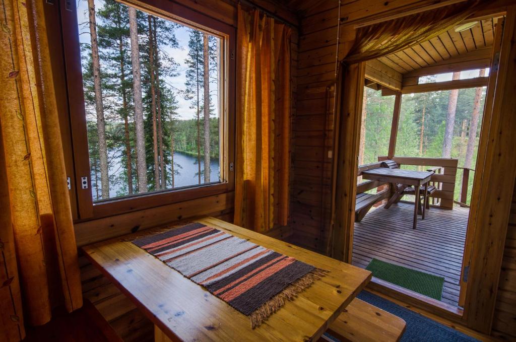 a wooden cabin with a table and a window at Ahvenlampi Camping in Saarijärvi