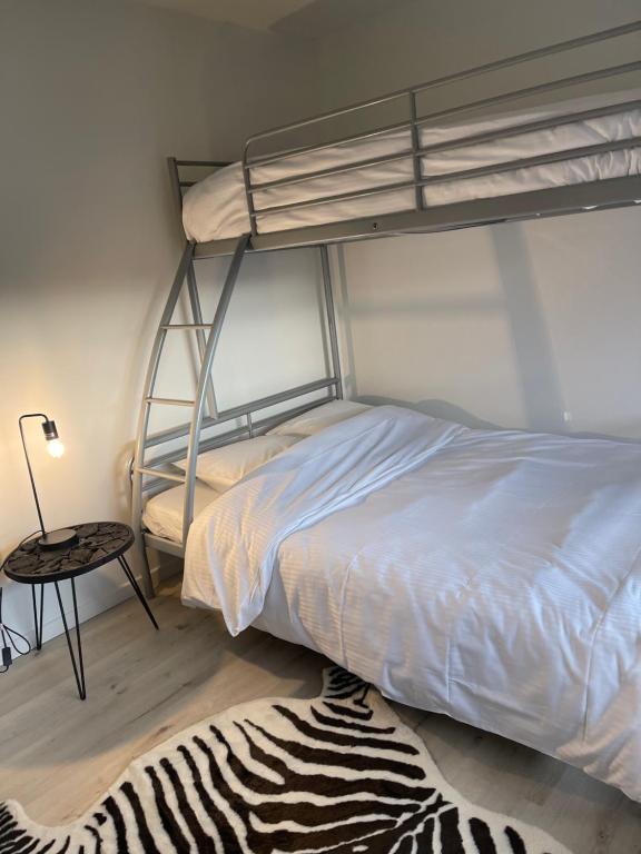 sypialnia z łóżkiem piętrowym i dywanem zebry w obiekcie NEOZONE Appart-Hotel Malmedy w mieście Malmedy