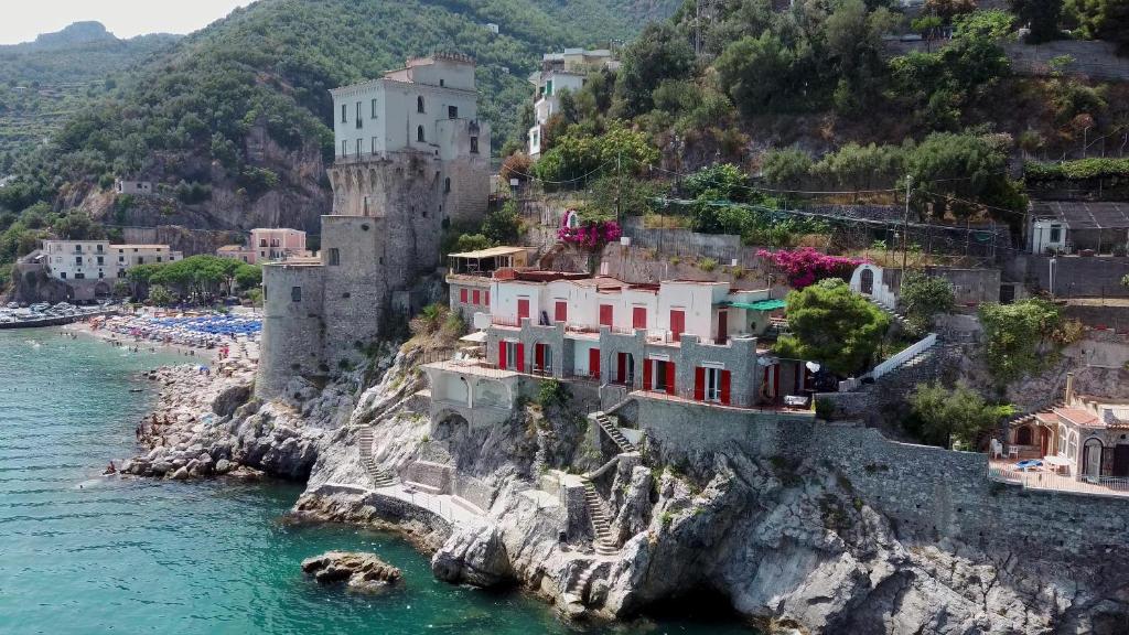 Villa Venere - Amalfi Coast في سيتارا: مجموعة منازل على منحدر بجانب الماء
