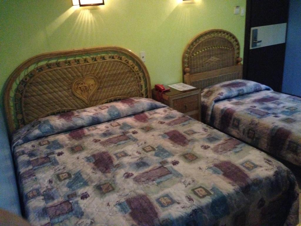 杜馬格特的住宿－RM賓館，一间卧室配有两张床,床上配有床罩