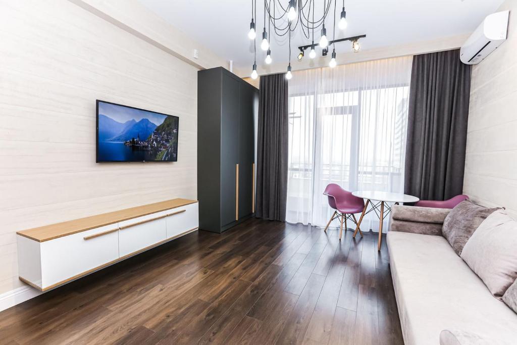 een woonkamer met een bank en een tafel bij Sky House Premium Rent in Chişinău