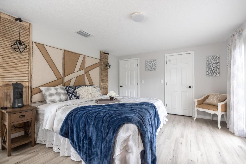 a bedroom with a large bed with a blue blanket at Cozy Apartments in the Triplex House, Historic District of Orlando in Orlando