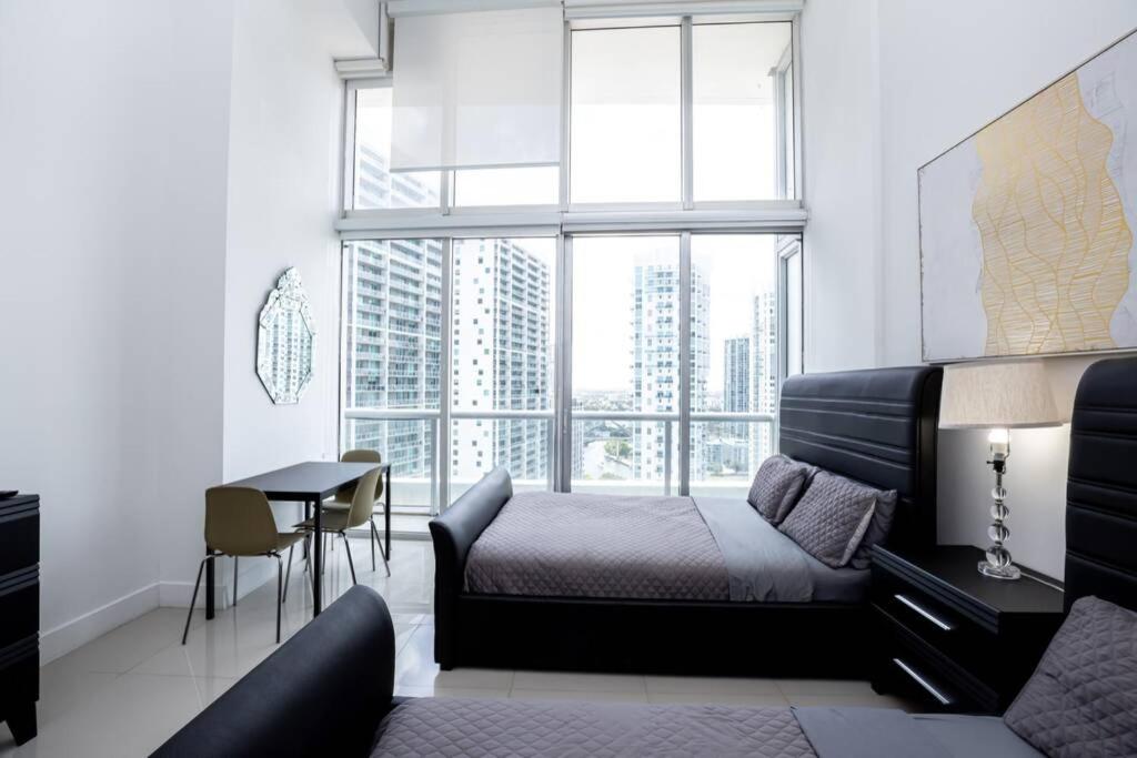 a bedroom with a bed and a desk and a window at ICON/W HOTEL LUXURY STUDIO@MIAMI DOWNTOWN/BRICKELL in Miami