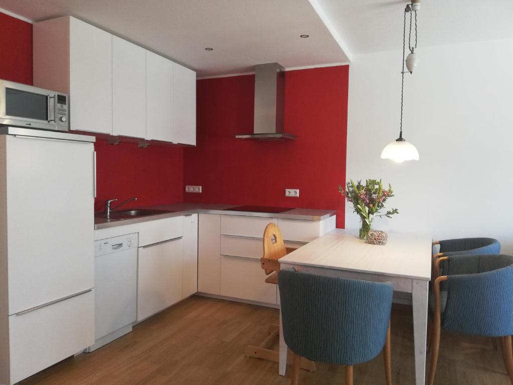 a kitchen with white cabinets and a table with blue chairs at Barrierefreies Appartement auf der Alb in Trochtelfingen