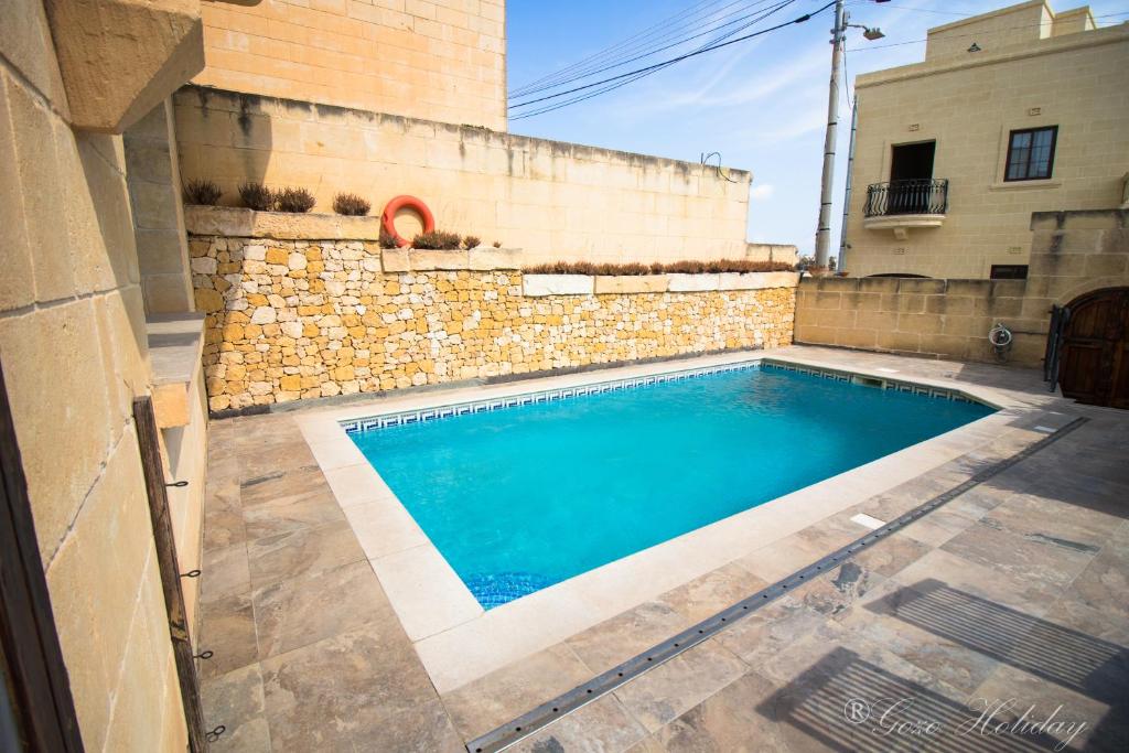 a swimming pool in front of a building at Mandolina Casa in Għarb