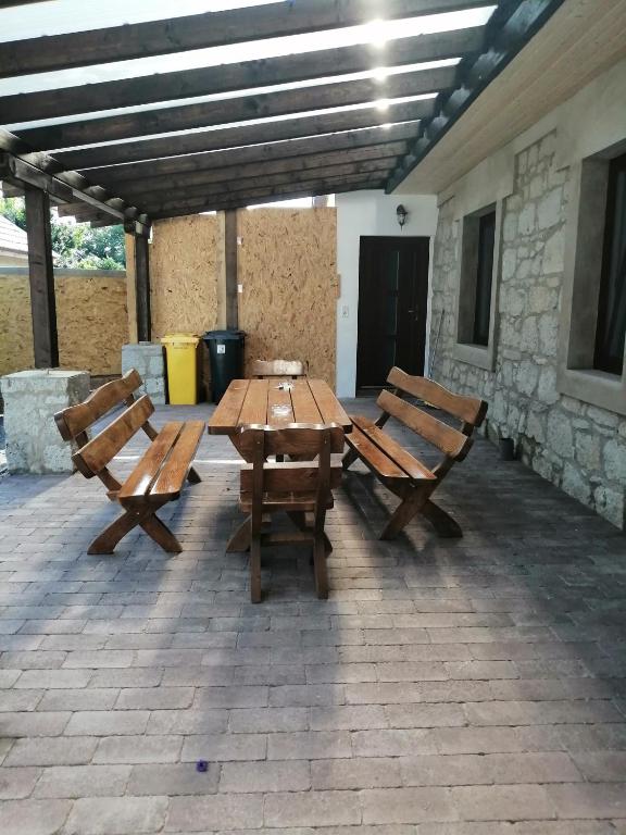 a picnic table and two benches on a patio at Cinege Vendégház in Tolcsva