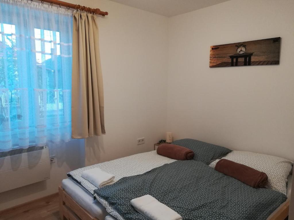 een kleine slaapkamer met een bed en een raam bij Cinege Vendégház in Tolcsva