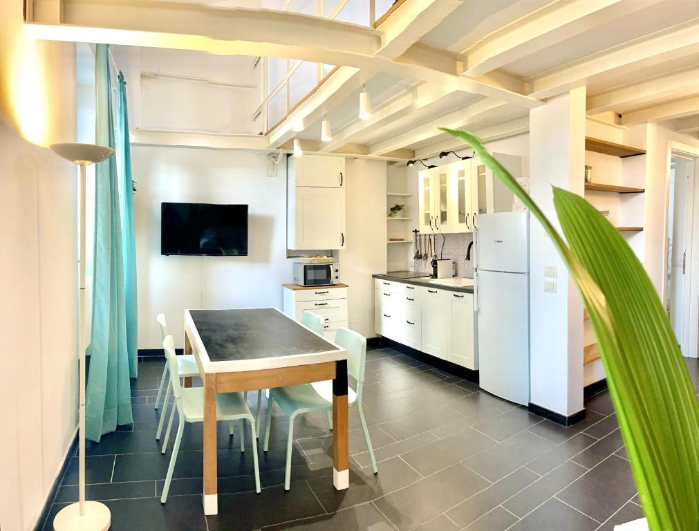 una cucina con tavolo, sedie e frigorifero di COZY LOFT MARINA VIEW a Savona