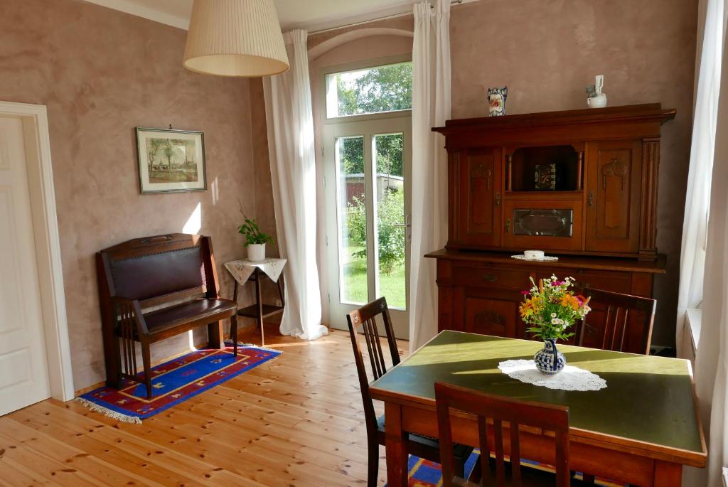 d'une salle à manger avec une table, des chaises et une fenêtre. dans l'établissement Ferienwohnung ANDERE ZEITEN, à Frankenberg