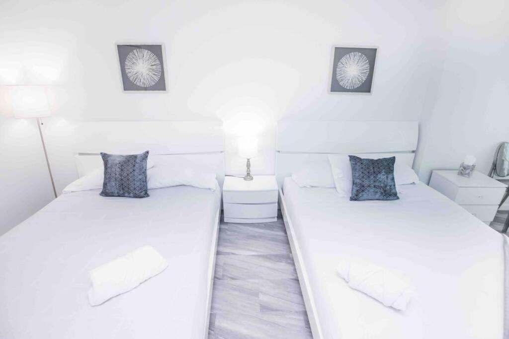 two beds in a room with white walls at Spectacular Studio at Brickell, Free Parking in Miami