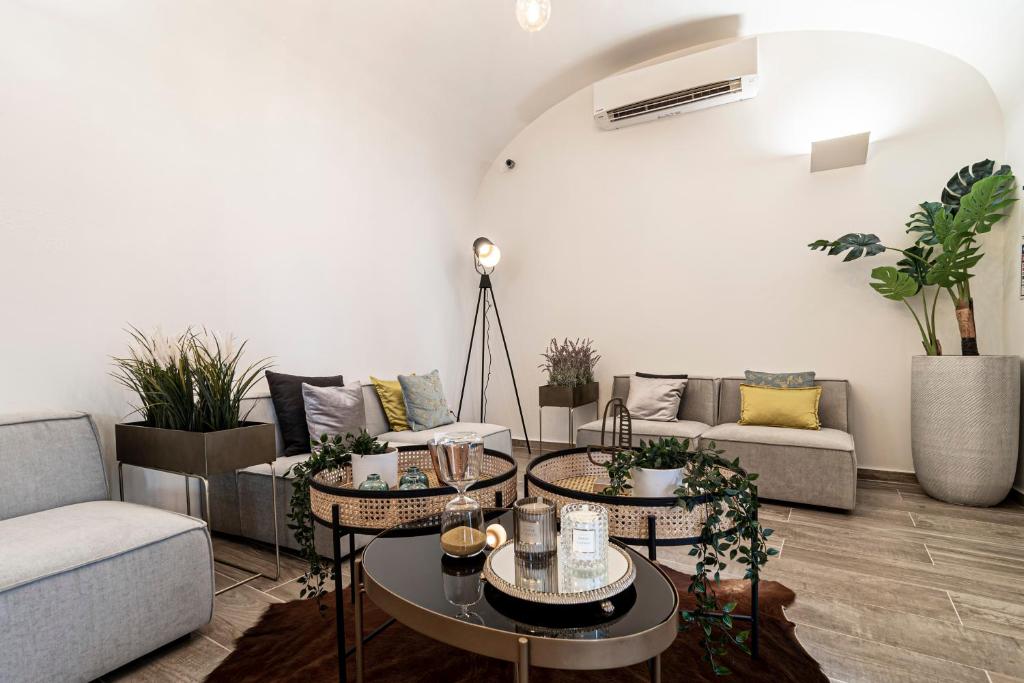 ein Wohnzimmer mit Sofas, Tischen und Pflanzen in der Unterkunft Templo Boutique Hotel in Évora