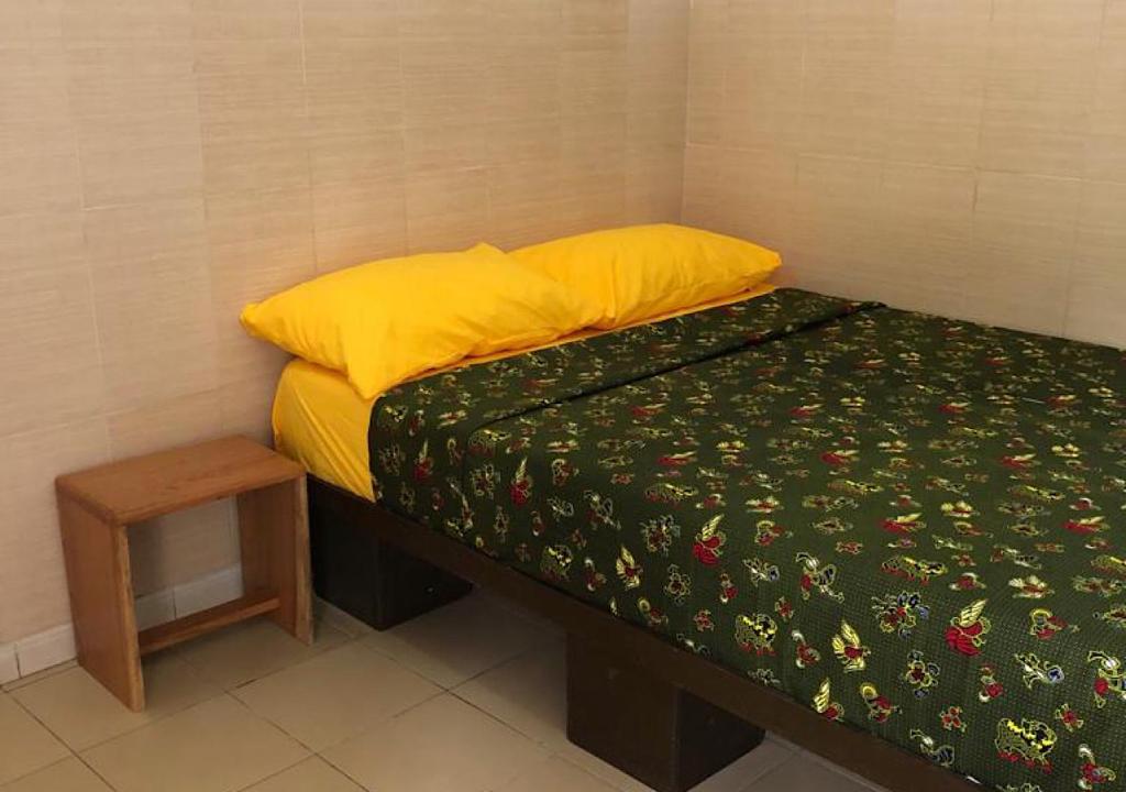 a small bedroom with a bed and a night stand at Villa CB in Abidjan