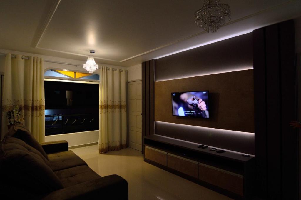 sala de estar con TV de pantalla plana en la pared en Cobertura 3 dormitorios no Centrinho Canasvieiras, en Florianópolis
