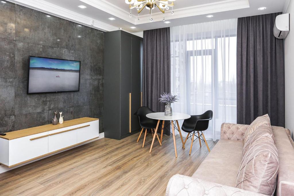 奇西瑙的住宿－DOUBLE SkyHouse Exclusive Apartments，客厅配有沙发和墙上的电视