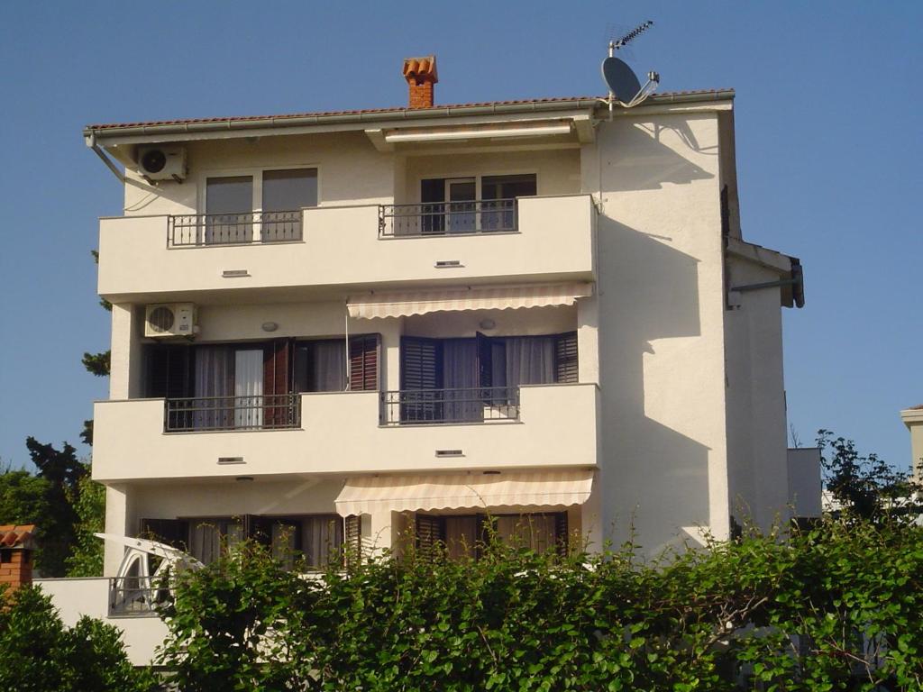 un edificio blanco con un pájaro encima en Apartments Buljan, en Kožino