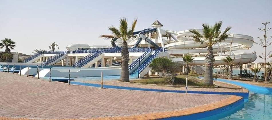 a resort with a slide in front of a building at شاليه بقرية أندلسيه بمطروح يرى البحر in Marsa Matruh