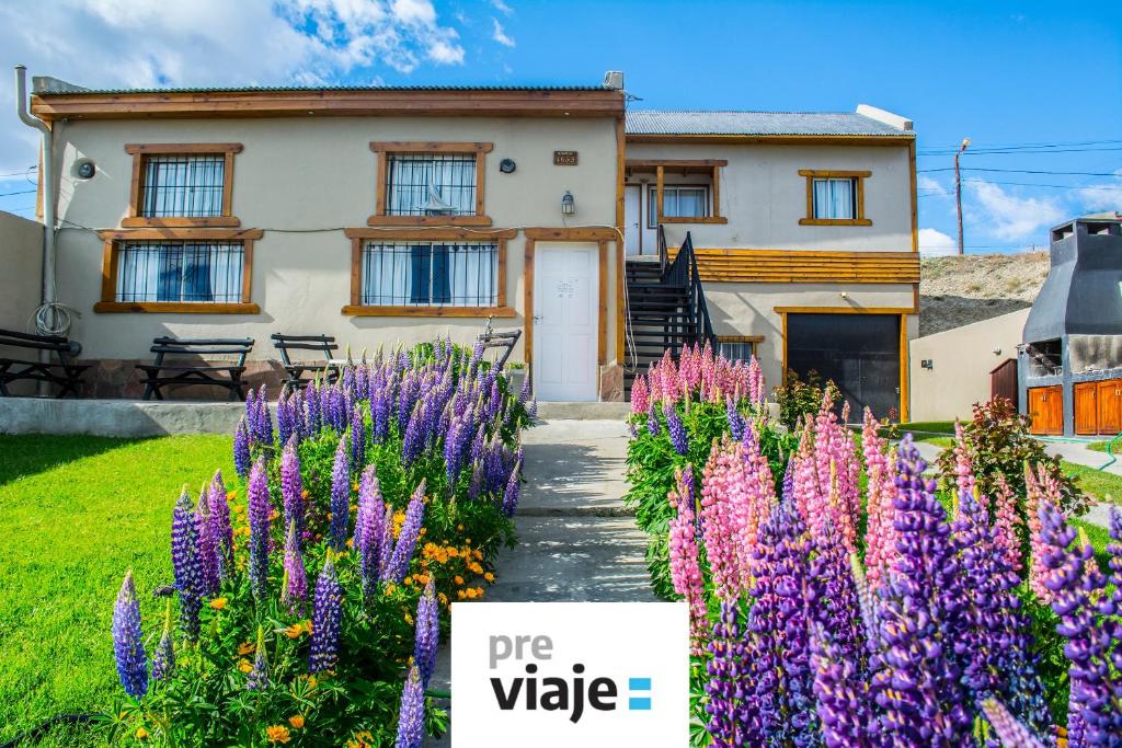 una casa con flores púrpuras delante de ella en Apart Haiken en El Calafate