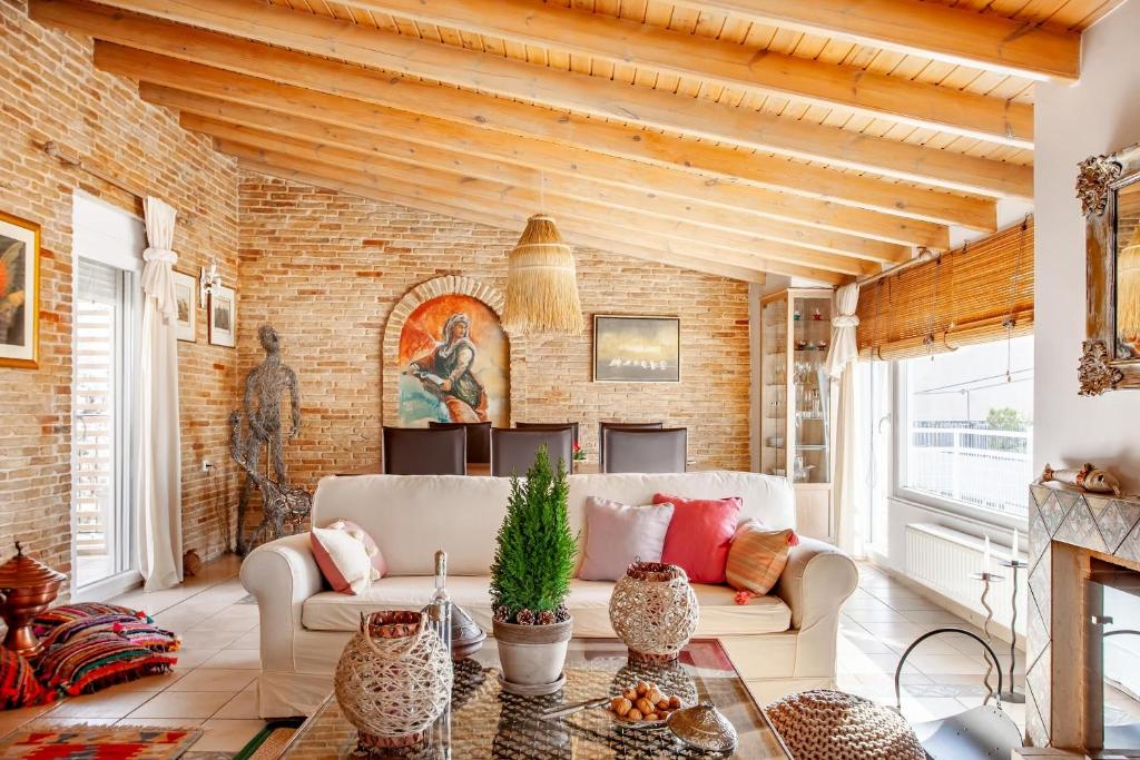a living room with a couch and a brick wall at Σοφίτα μοναδικής αισθητικής in Athens