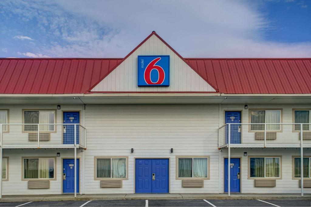 a building with a red roof with a sign on it at Motel 6-Baker City, OR in Baker City