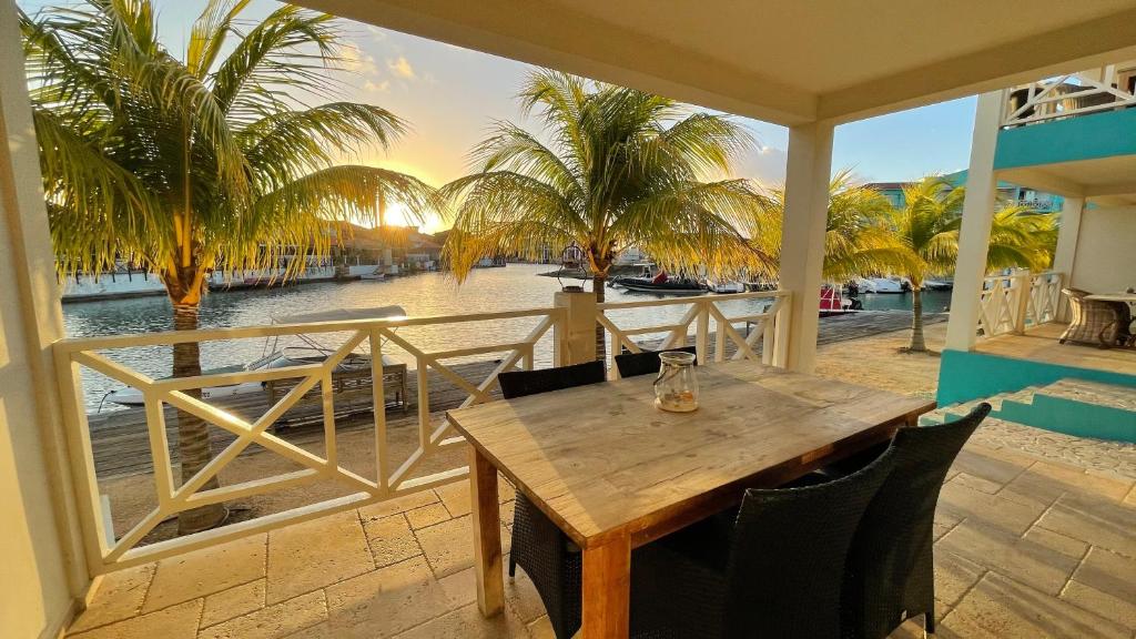a wooden table on a balcony with a view of the water at Caribbean Lofts Bonaire in Kralendijk