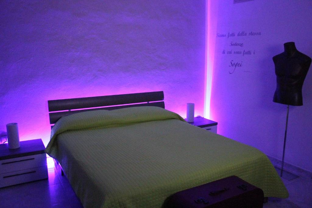 a bedroom with a bed with pink lights on it at Camere Amarzè Plus in Portopalo