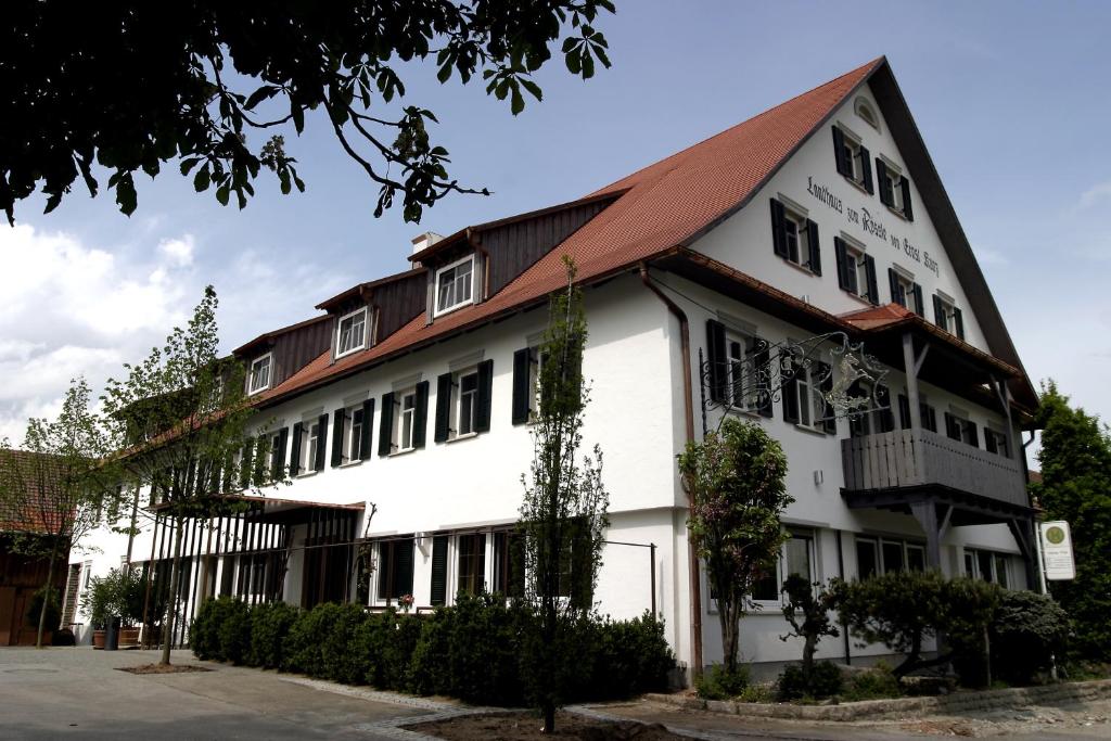 un bâtiment blanc avec un toit rouge dans l'établissement Landhaus Rössle, à Schwäbisch Hall