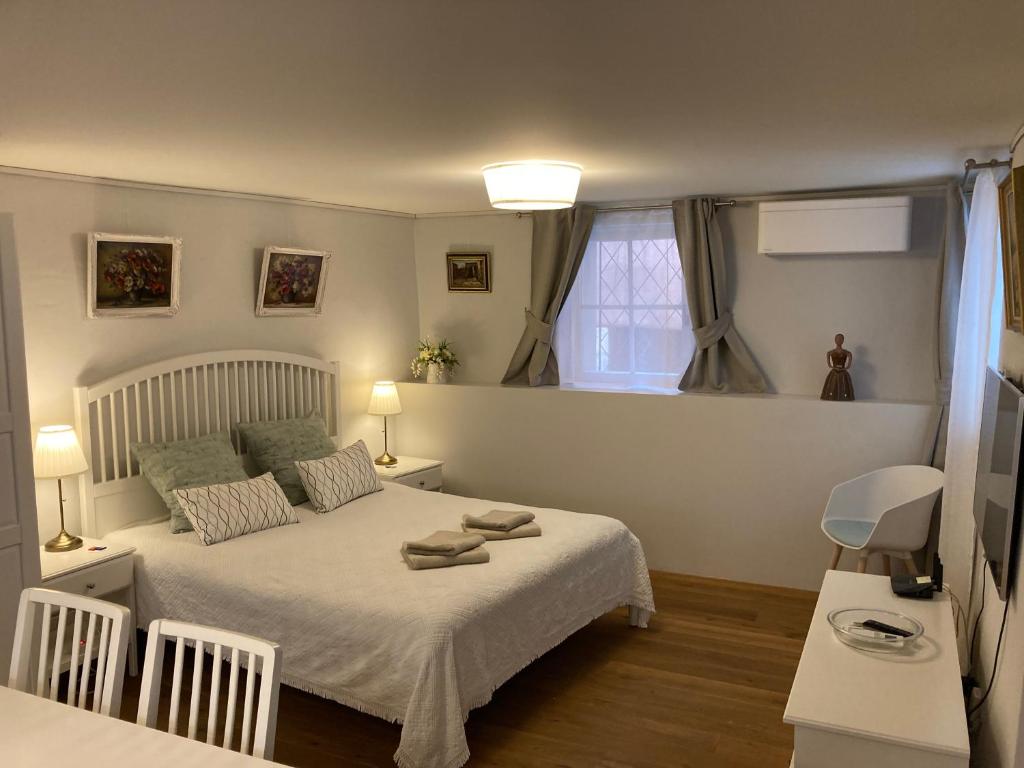 a bedroom with a white bed and a window at Studio de luxe, au coeur de la vieille ville in Sion