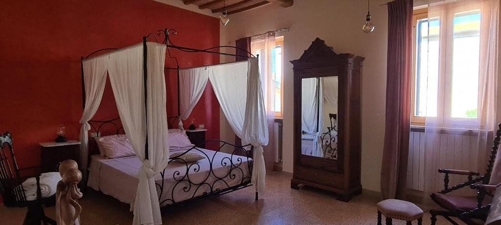 a bedroom with a canopy bed and a mirror at Il Nido del Cuculo in Petrignano
