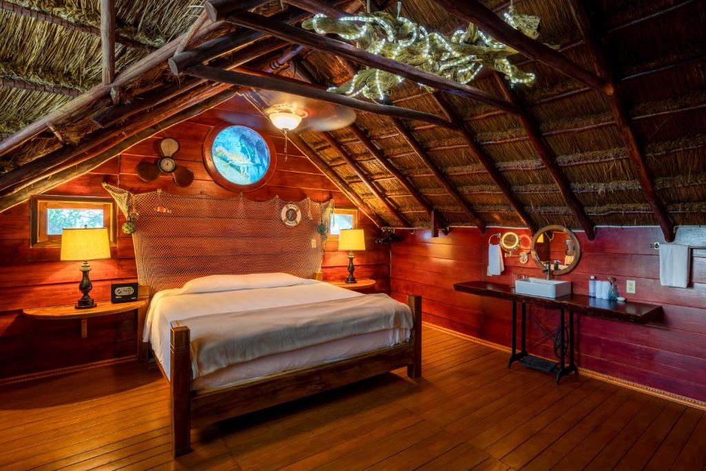 1 dormitorio con 1 cama en una habitación con paredes de madera en The Diving Lodge Downtown en Puerto Morelos