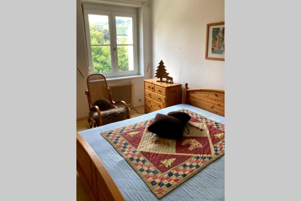 Un dormitorio con una cama con una alfombra. en Cozy Condo close to town, castle, lake and hiking, en Wolfsberg