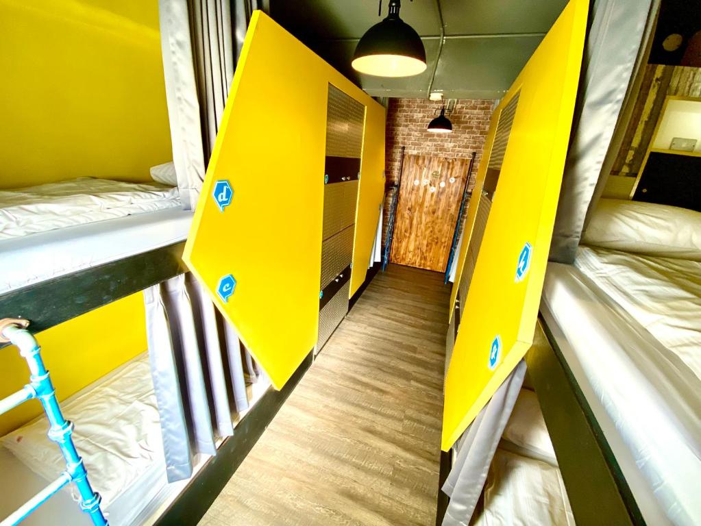 two bunk beds in a room with yellow walls at Hive Bed and Backpacker蜂巢膠囊旅店 in Hualien City