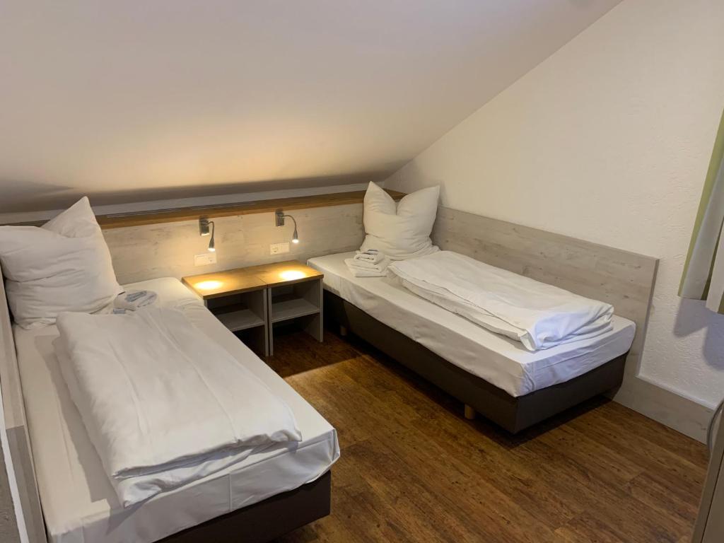 a small room with two beds and a table at Hotel Waibstadter Hof in Waibstadt