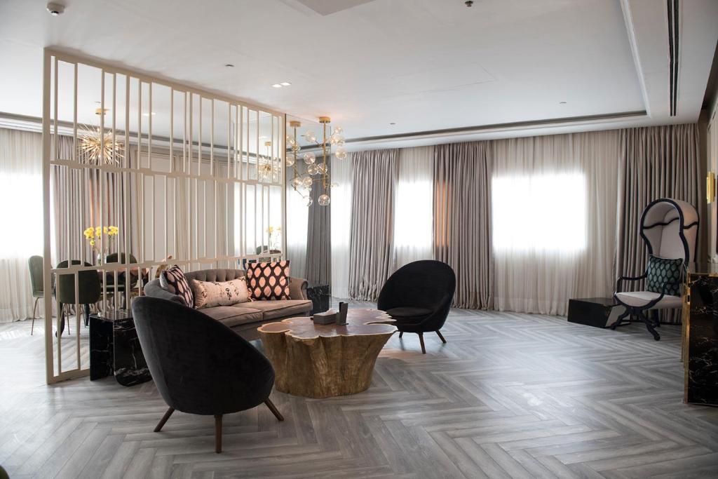 拉合爾的住宿－尼莎喬哈爾鎮酒店，客厅配有沙发、椅子和桌子