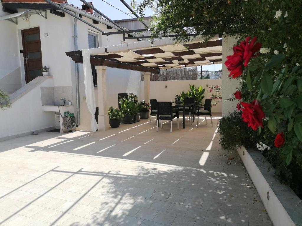 een terras met een tafel en stoelen onder een pergola bij Holiday House Tina in Pula