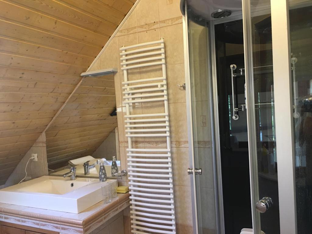 a bathroom with a sink and a wooden wall at Lavender in Hévíz