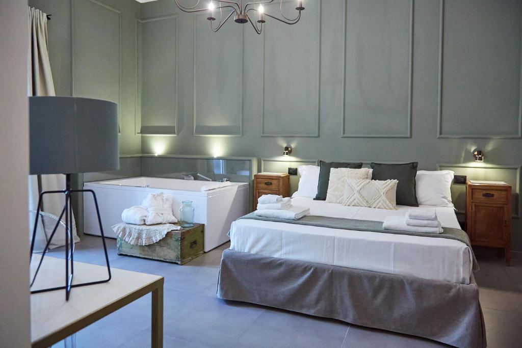 a bedroom with a large bed and a bath tub at Dimora Terranova Charming Rooms in Noto