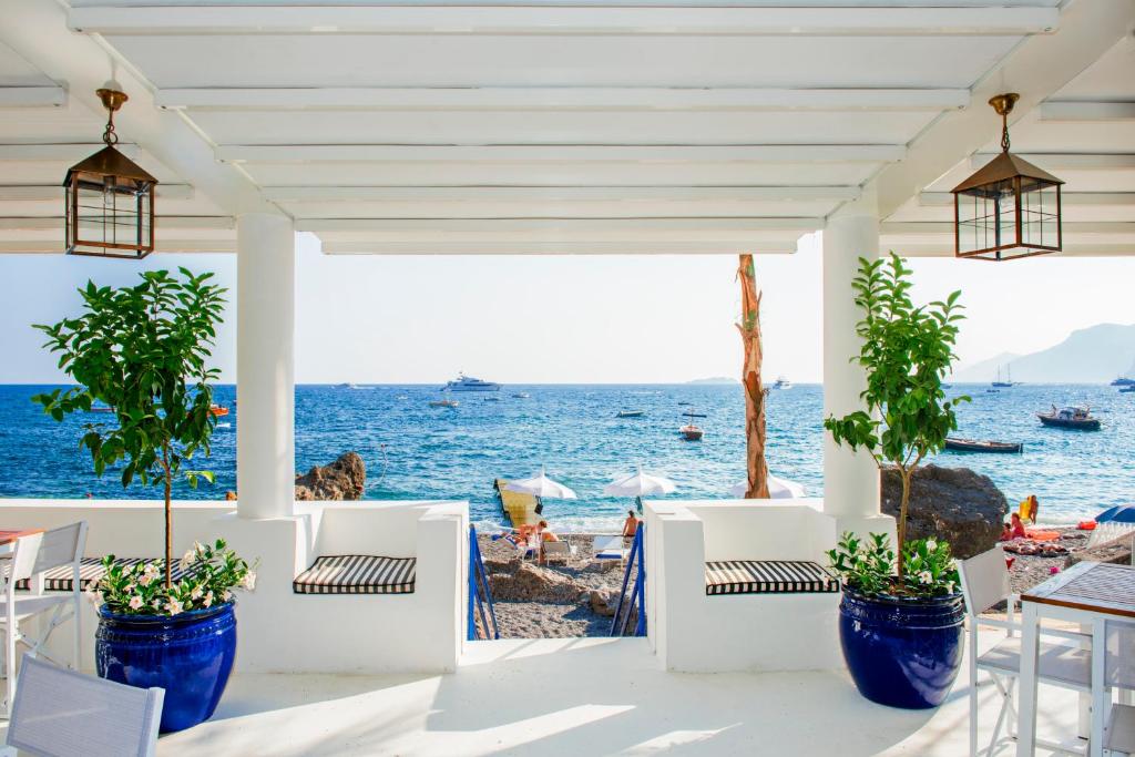 a patio with chairs and a view of the ocean at Laurito Beach Cucina & Camere in Positano