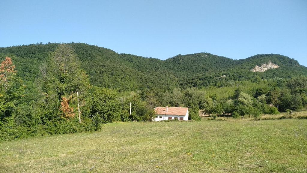 a house in a field in front of a mountain at Casa vacanze Monti della Laga in Torricella Sicura