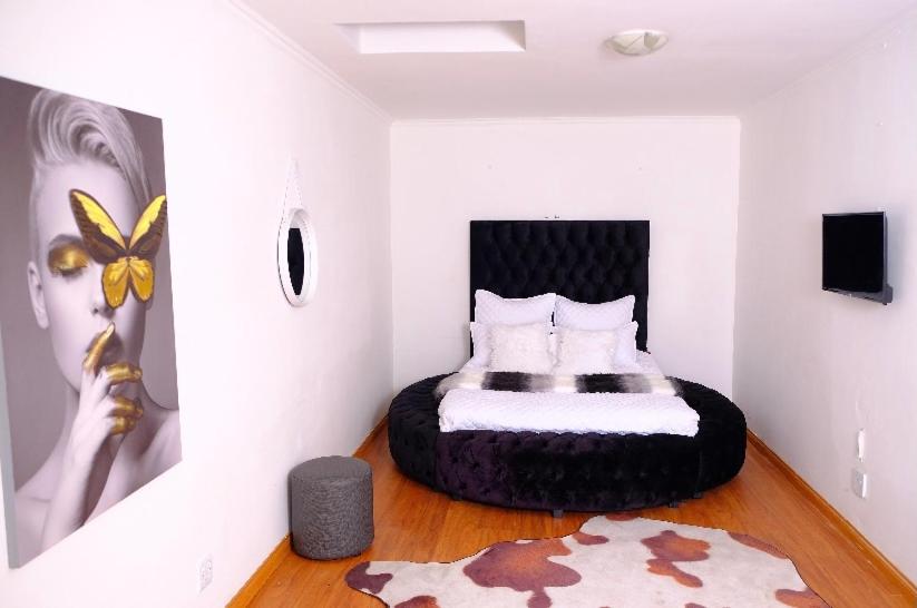 - une chambre avec un lit dans l'angle dans l'établissement Selina Airport Lodge #Emzini, à Kempton Park