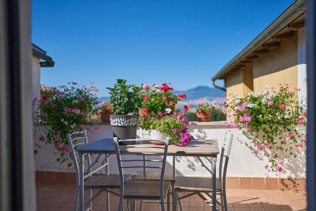 een tafel en stoelen met bloemen op een balkon bij Casetta Bea in Celle sul Rigo