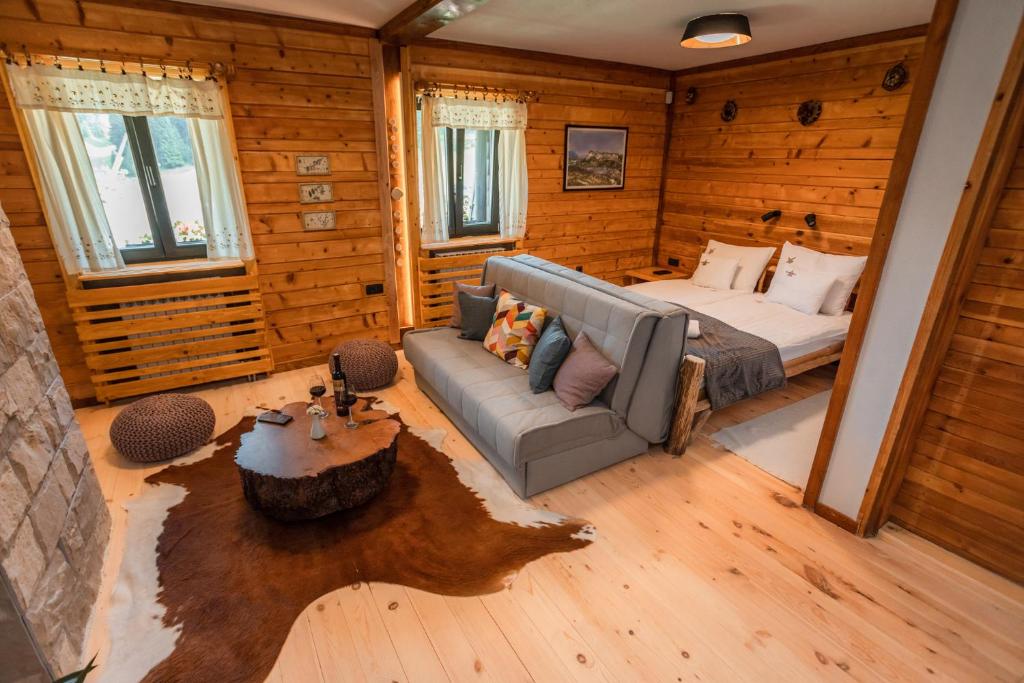 a bedroom with a bed and a couch in a room at Hotel Rajska Vrata in Jahorina